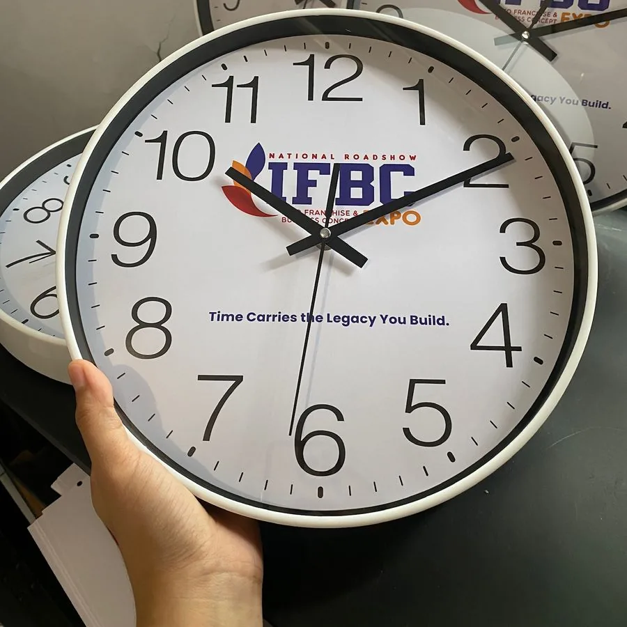 Jam dinding bertumpuk berlogo navy IFBC Expo dengan latar gelap
